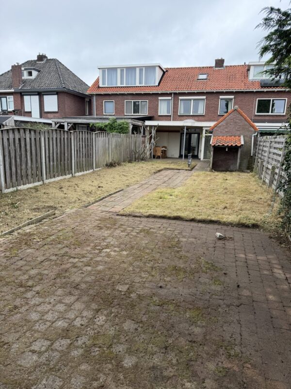 Achtertuin in Almelo ná het tuinonderhoud door CleanNL — gazon gemaaid, borders en bestrating vrijgemaakt